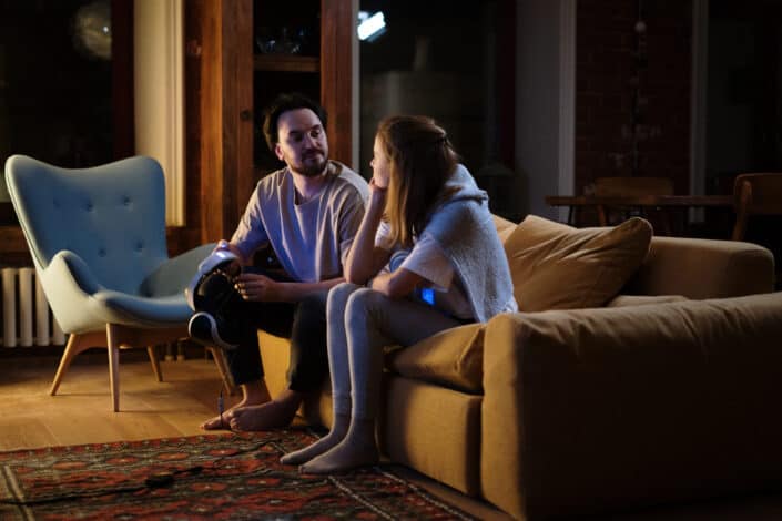 couple talking while sitting on a couch.