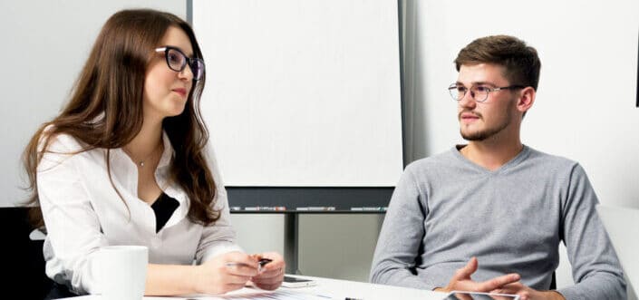 colleagues talking while sitting together in the office