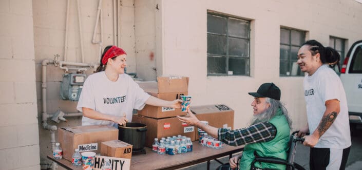 Old man receiving relief goods from volunteers