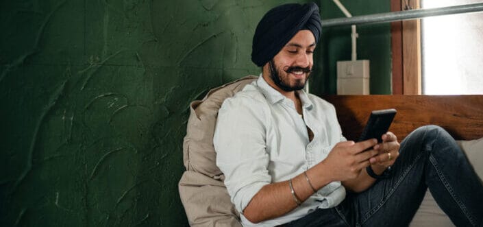 Man delightedly reading a text message.