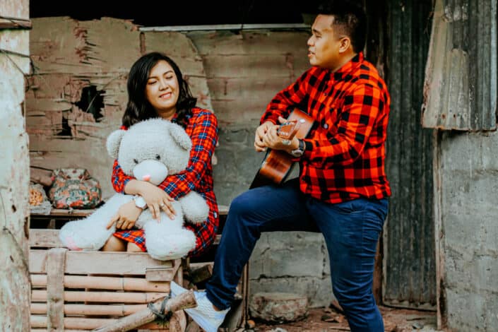Man serenading his woman with a guitar.