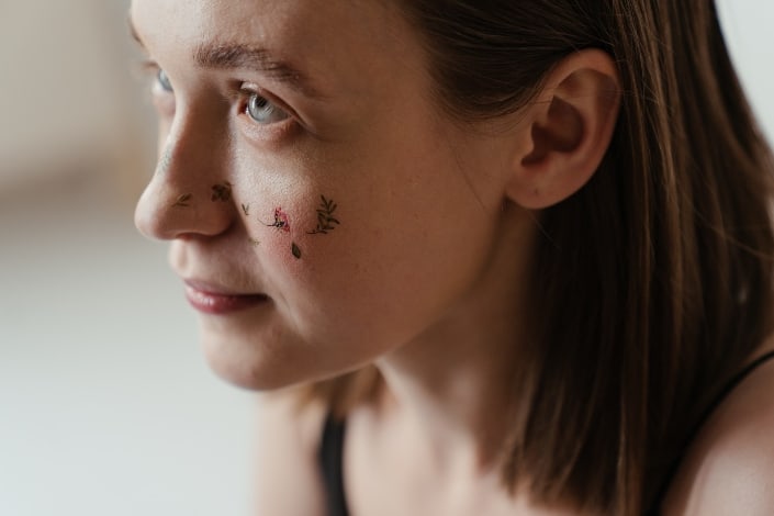 Woman With Floral Art Tattoo on Her Face
