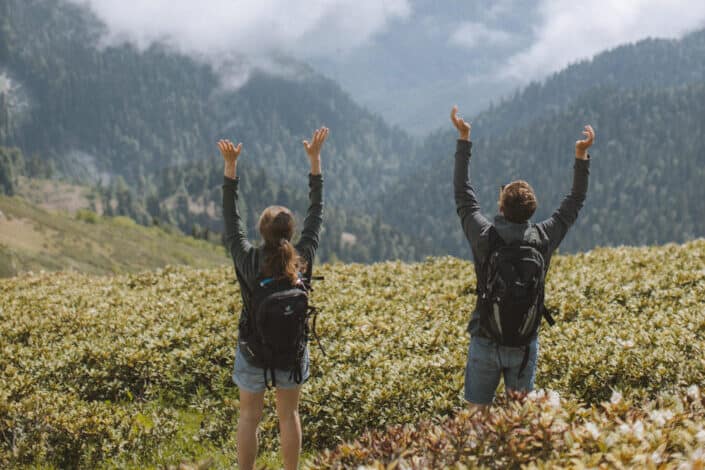 couple celebrating as they climb the mountain's peak.
