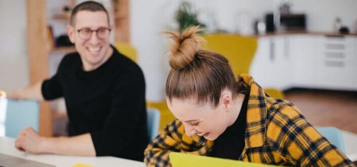 Two colleagues laughing while walking.