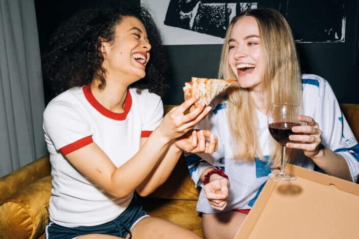 Women Having Fun While Eating Their Pizza