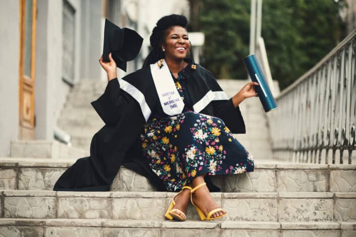 Woman posing while sitting and wearing a toga.