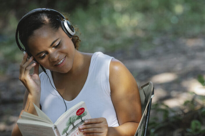 Woman reading a book while listening to music