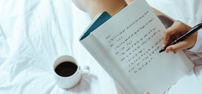 Woman writing while having coffee