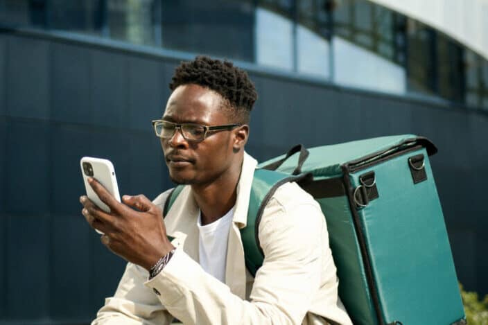 Man with Thermal Backpack Using Cellphone