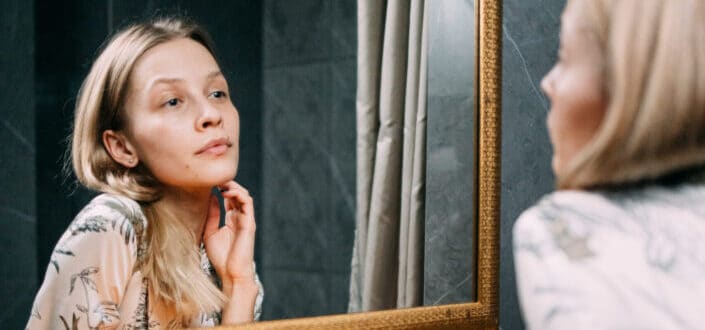 woman feeling pretty while looking at her reflection