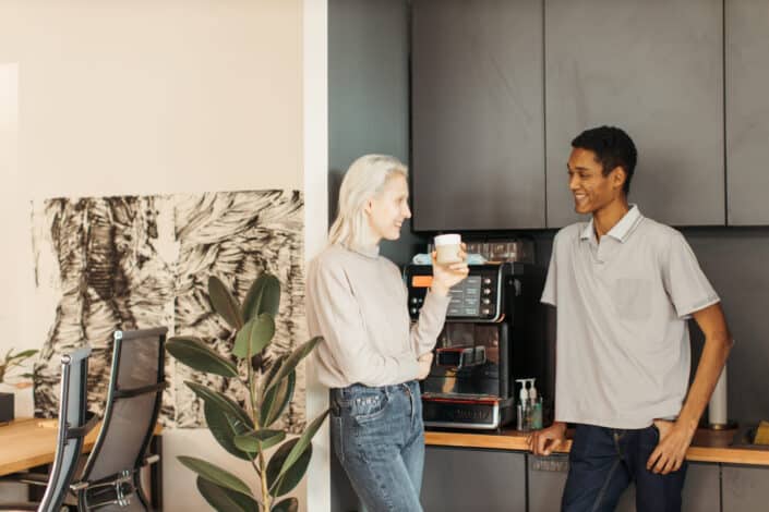 colleagues Having Fun Conversation in Office Pantry