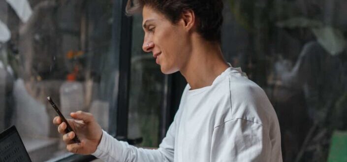Man in White Long Sleeve Shirt Using Gadgets