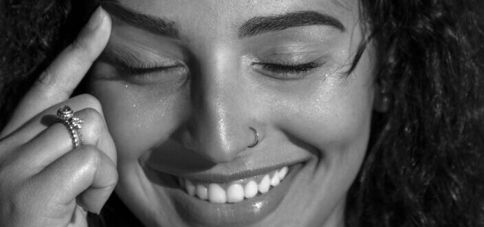 Smiling Woman Touching Her Eyebrow