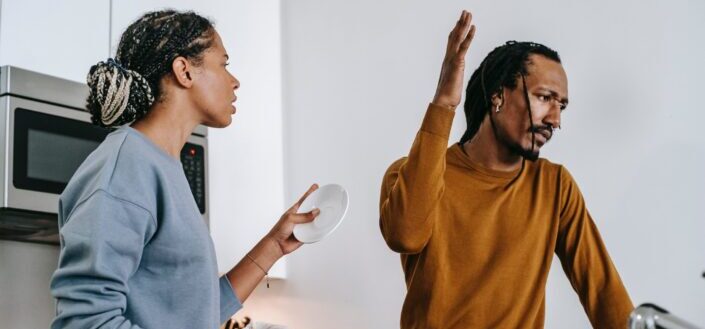Couple arguing in kitchen at home.