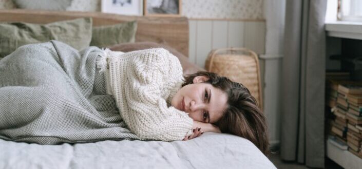 Woman crying on her bed.