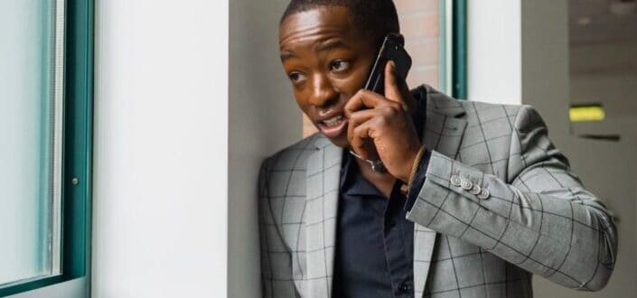 A Man in a Gray Suit talking on the phone.