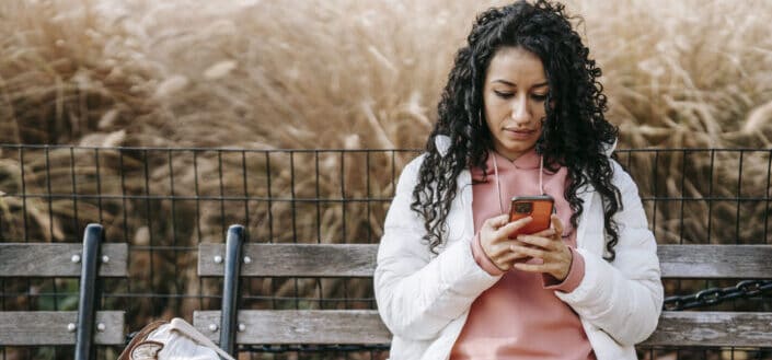 Curly haired woman looking at her phone 