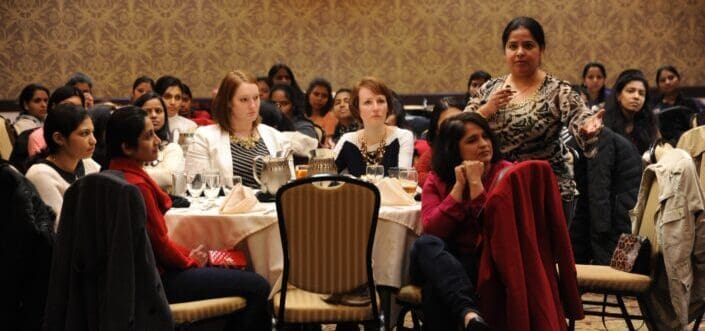 Woman asking a question while in a conference.
