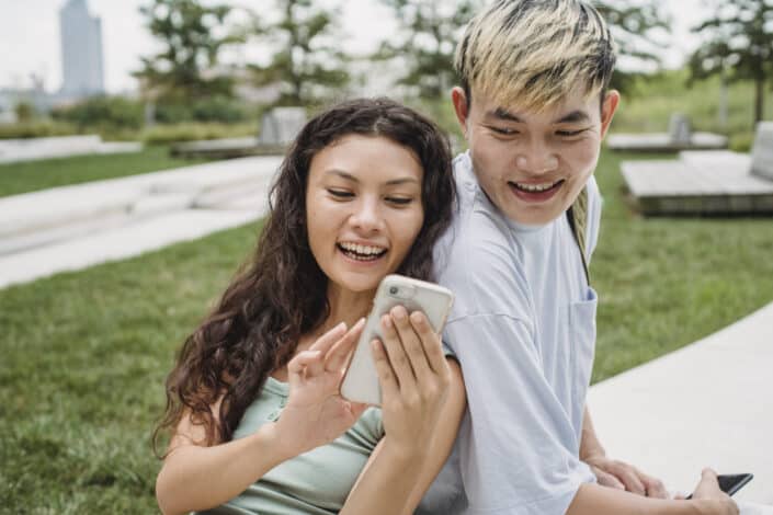 Couple smiling while looking at the girl's phone