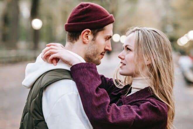 Man and woman staring at each other in street - Does He Love Me