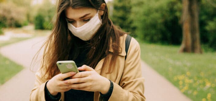Masked woman looking at her phone