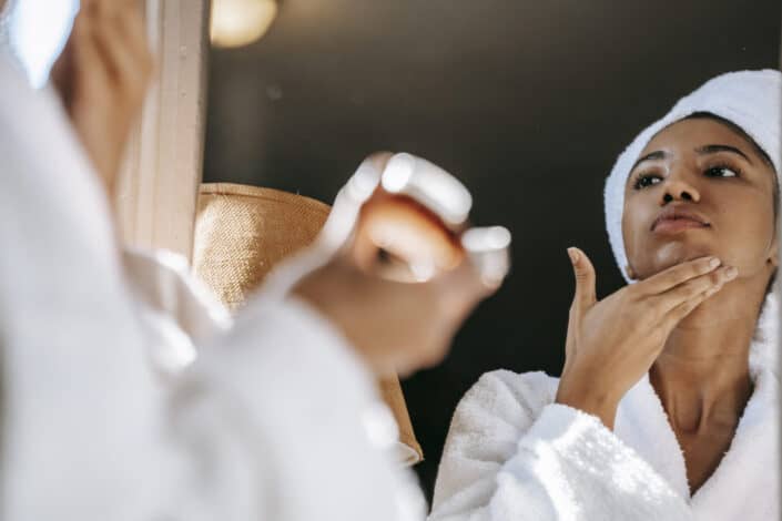 Woman putting on some face moisturizer