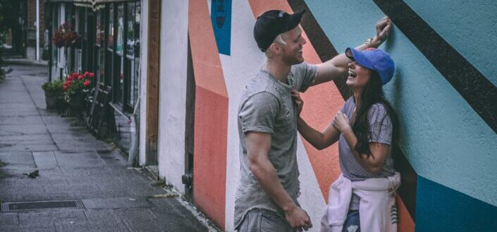 man leaning on wall facing his girl
