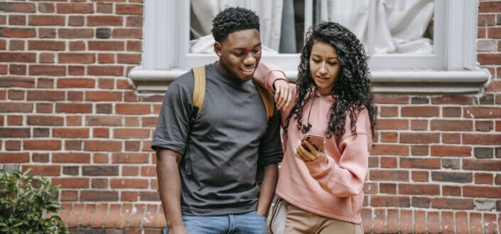 Couple both looking at something on the girl's phone