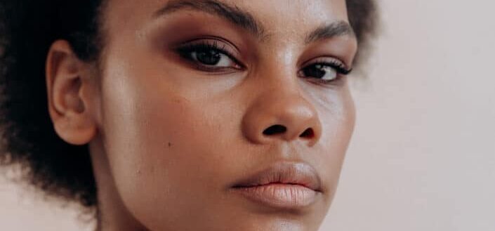 Woman with light makeup looking at a camera