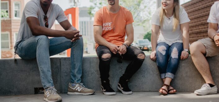 four persons sitting on concrete bench