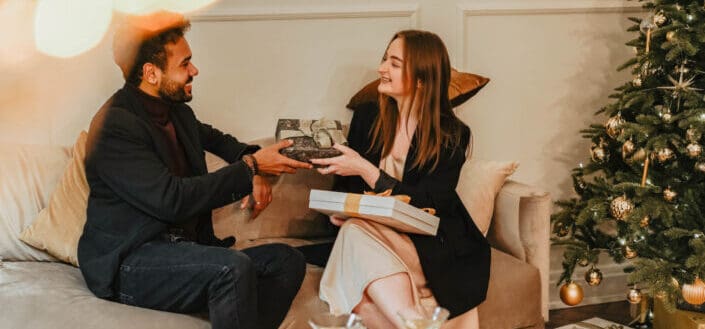 Couple exchanging Christmas gifts to each other