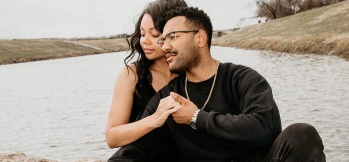 couple sitting beside a lake