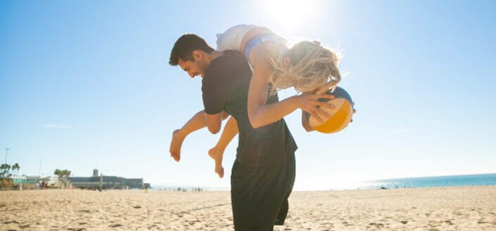 Couple playing in the beach on a sunny weather