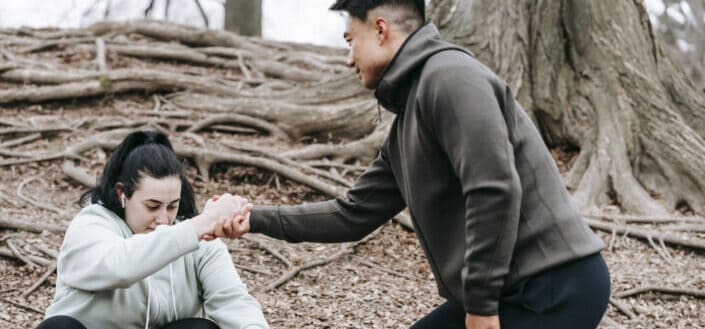 Man helping her girlfriend to stand up