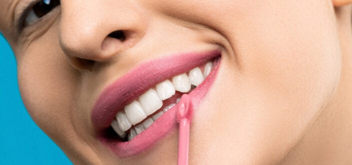 Lady putting on some pink liquid lipsticks