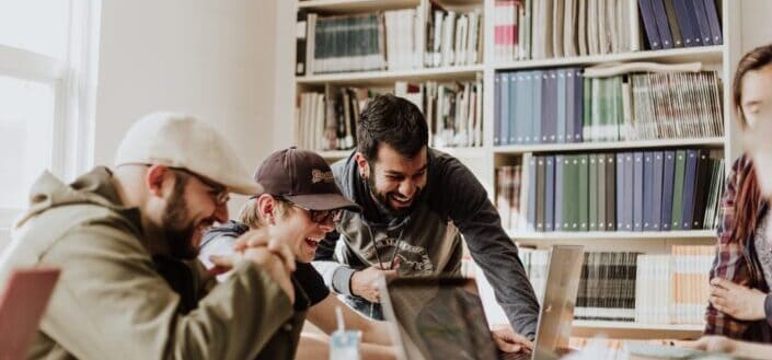 men laughing while looking in the laptop