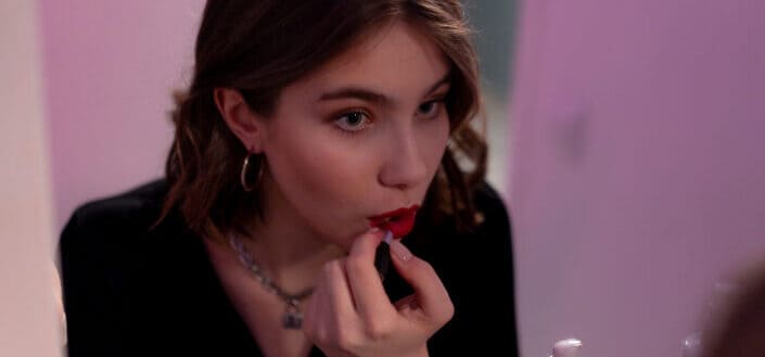 Lady fixing her lipstick in the mirror