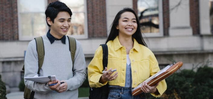 Two youngsters walking while discussing 