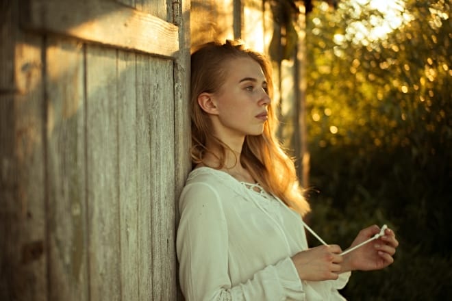 Woman Wearing White Top Leaning on Wooden Wall - How to get over being cheated on
