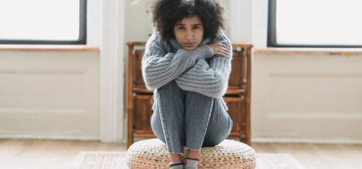 sad girl sitting on a cushion