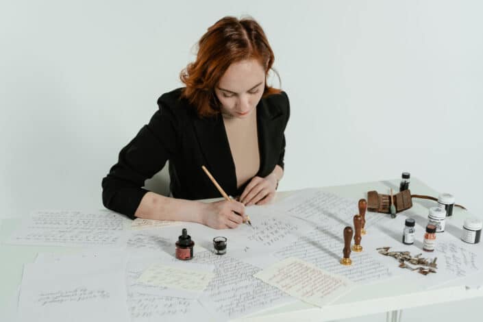 Woman in Black Blazer Writing on Paper