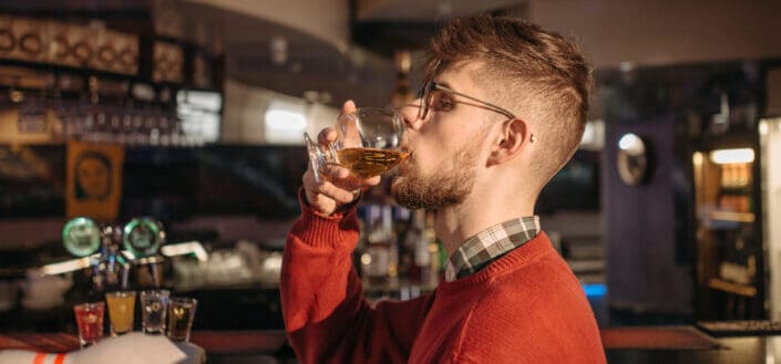 Man Drinking Alcoholic Beverage at the Bar Counter