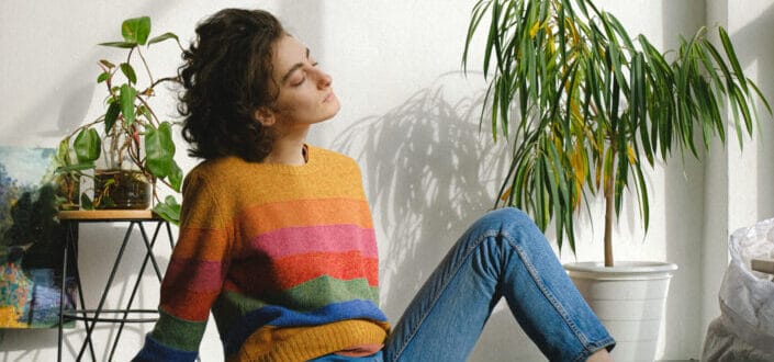 Dreamy young artist having rest sitting on floor