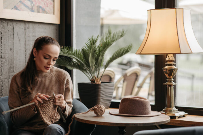 Woman in Sweater enjoying knitting