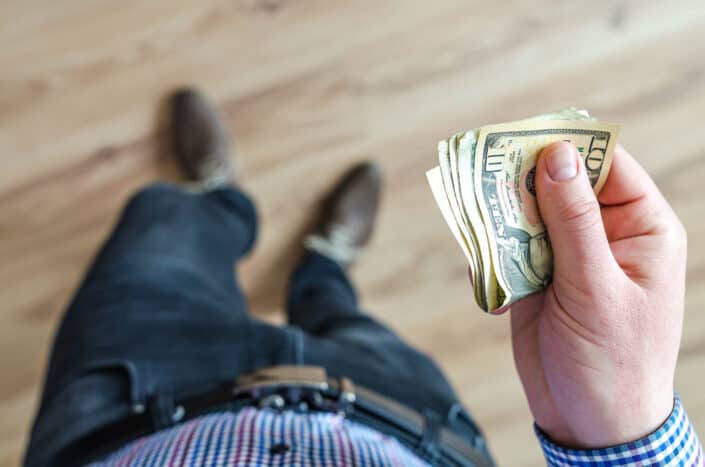 Man handing over a fold of money.