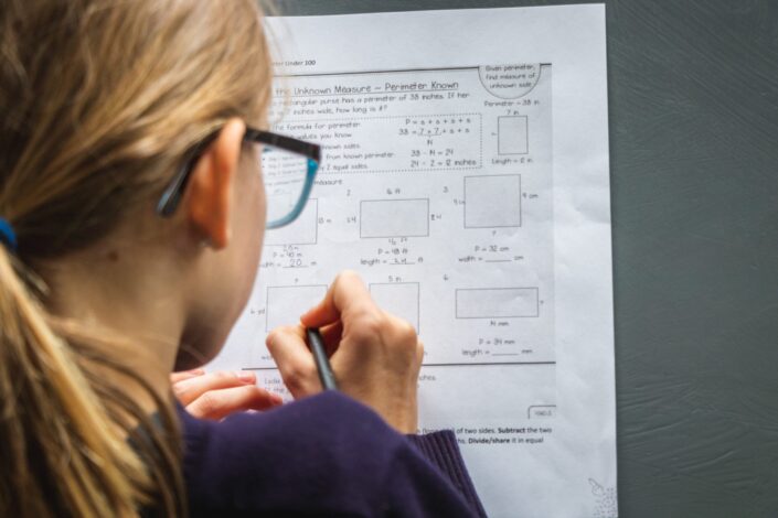 girl with glasses working on school work