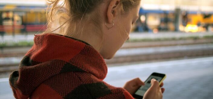 a back of a woman checking Her Smartphone