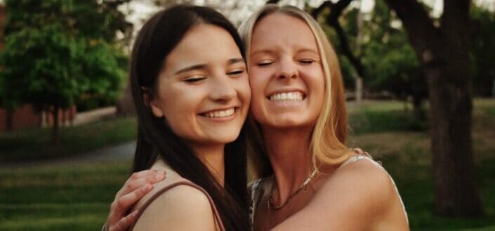 Two women hugging and smiling 