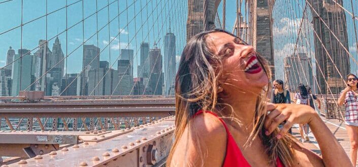 Lady in a red dress and lipstick laughing in a bridge