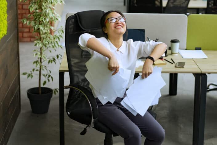 A woman about to throw papers in celebration.